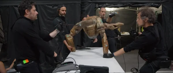 複数のパペティア（人形操演者）たちが協力し、複雑な動きをするクリーチャーのパペットに命を吹き込んでいる撮影の舞台裏