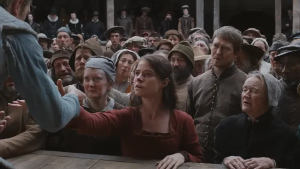 グローブ座の客席から、舞台上のハムレットに向かって手を伸ばすアグネス