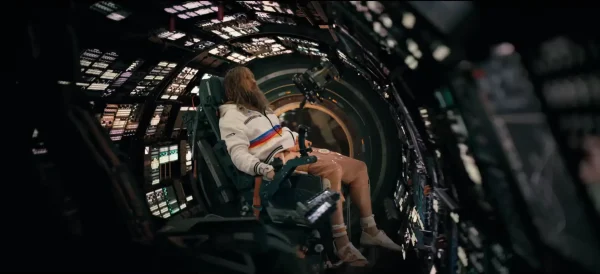 ヘイル・メアリー号の船内で、青く光る多数のモニターや電子計器に囲まれながら、真剣な表情でシステムを操作するライランド・グレース