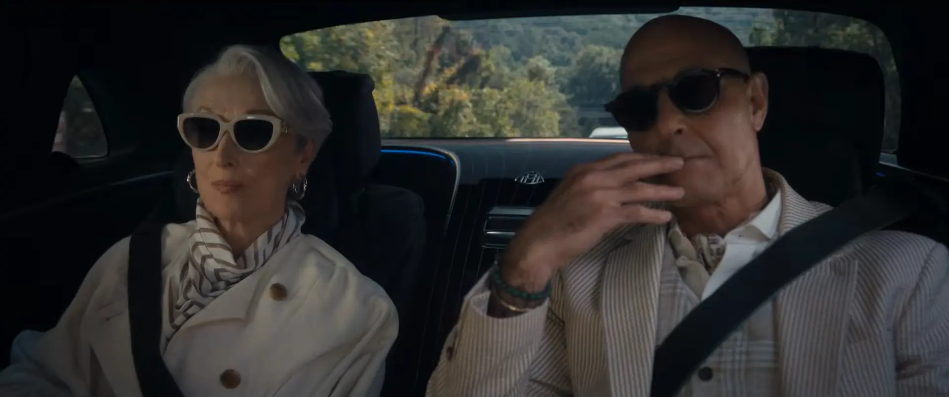 車の後部座席に並んで座るミランダとナイジェル