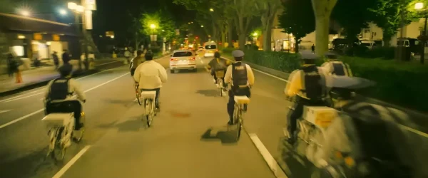 新宿・歌舞伎町の公道でママチャリに乗ってチェイスする相葉四郎(水上恒司)とチェ・シウ(ユンホ)
