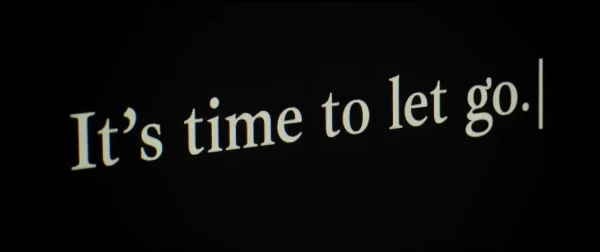 パソコンの黒い画面に「It's time to let go」とタイピングされた文字