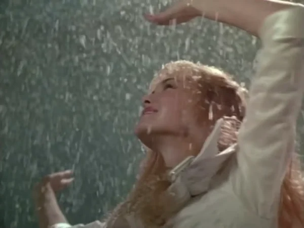 氷の彫刻から舞う雪の下で踊るキム