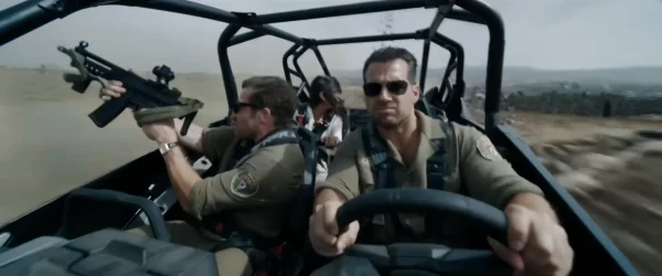 『グレイ・ミッション』でジープを猛スピードで運転するシド(ヘンリー・カヴィル)と、助手席から銃を構えて応戦するブロンコ(ジェイク・ギレンホール)