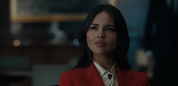 映画『グレイ・ミッション』でスタイリッシュなスーツを着用し冷徹な表情で法的交渉に臨むレイチェル・ワイルド役のエイザ・ゴンザレス