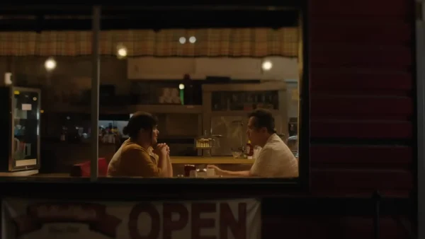 映画『私たちは、ちょうどいい。』で並んで座り穏やかに会話を交わすリリー（バービー・フェレイラ）とボブ（ジョン・レグイザモ）