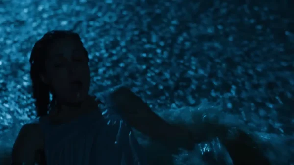 映画『ワンオペレーション』でモントーク海岸の砂浜に横たわる主人公リンダ（ローズ・バーン）